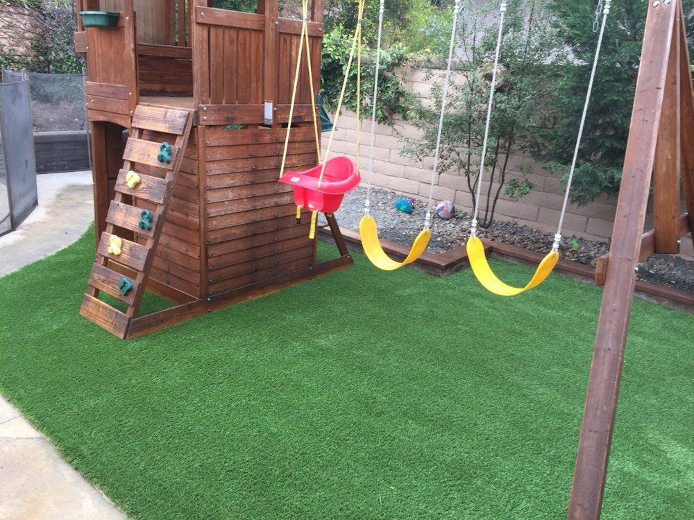 Turf play area under a wooden swing set